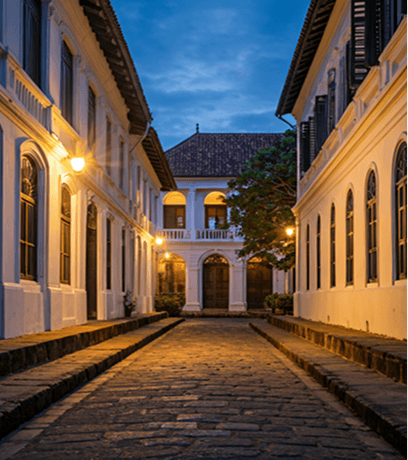 Lantern-lit cobblestone street through historic Galle Fort at dusk