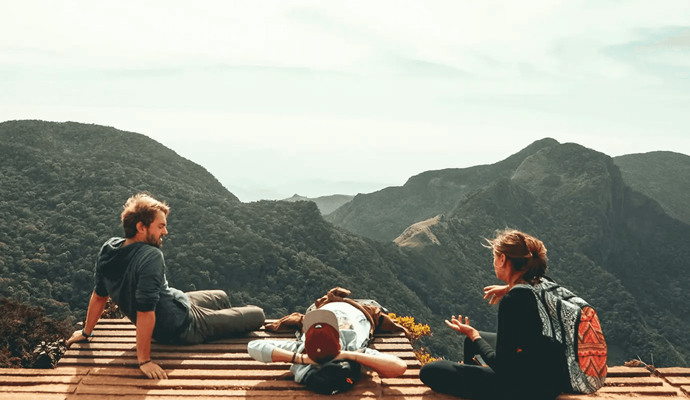 Guests overlooking a misty mountain landscape at sunset from a wooden deck