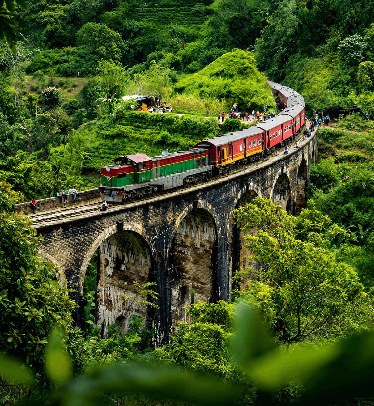 Scenic train journey crossing a stone bridge through Sri Lanka's lush highlands