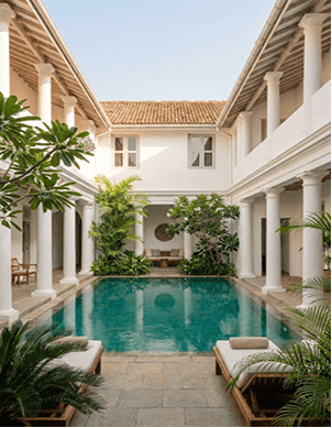 Luxury villa courtyard with a turquoise pool and white colonnades