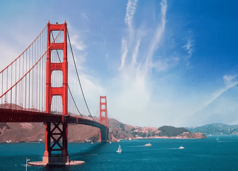 Golden Gate Bridge spanning San Francisco Bay under a bright blue sky